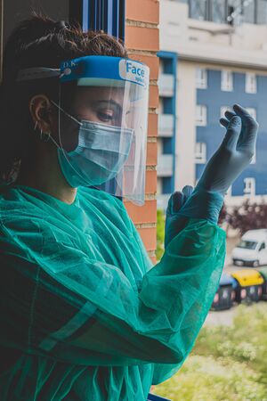 A woman wearing a medical mask, face shield and hands with a latex glove shows the symbol of the heart. Doctor for the heart. We love our medical professionals.の写真素材