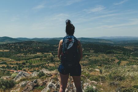 Rear view of a young woman with a backpack in the mountain hiking Trekking in the mountain.