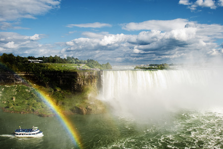 Barco pasando junto al arcoiris en las Cataratas del Niagaraの写真素材