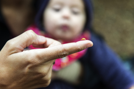 Blurred baby looking a yellow ladybugの写真素材