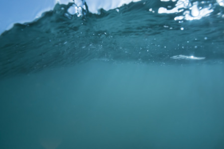 Underwater turquoise background in which the surface of the water is seen