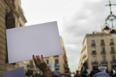 woman's hands in the foreground holding a blank banner to put the message you want during a...