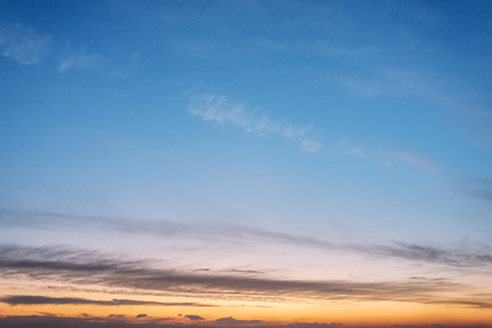 clear blue sky at sunset, there are some clouds on the orange horizon