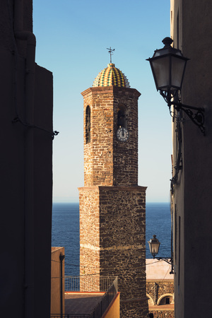 bell tower of the Castelsardo church in Sardinia, Italy, seen from the narrow streets of the citadelの写真素材