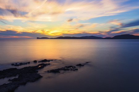 spectacular colorful sunset in the Gulf of Alghero, Sardinia, Italy. long exposure techniqueの写真素材