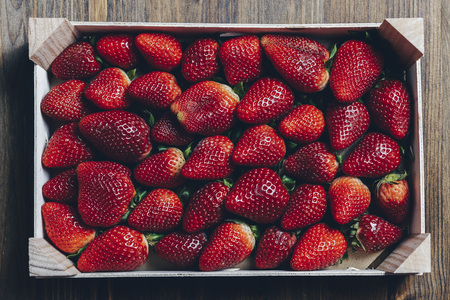 wooden box with strawberries on a wooden table, top view point, healthy sweet food, vitamins and fruity concept .Food frame background, flat layの写真素材