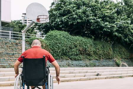 disabled man in wheelchair on the basketball court alone, concept of adaptive sports and physical activity, rehabilitation for people with physical disabilitiesの写真素材