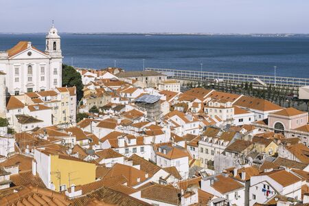 view of historic old district Alfama with river Tagus in the background at sunny day in Lisbon, Portugal, from the overlook of Portas do Solの写真素材