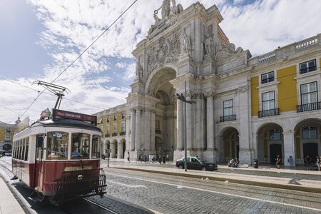Lisbon, Portugal august, 2019: old vintage tourist tram passing by the typical cobblestone street in front of augusta triumph arch streetのeditorial素材