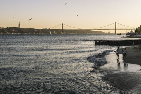 Lisbon, Portugal ? ?? august, 2019: children playing on the banks of the river Tagus at sunset with...