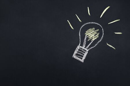 light bulb drawn with chalk on a blackboard, creativity concept for good ideas, copy space for text