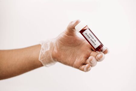 hand with glove taking a vial of blood sample infected with covid-19, medicine concept and...