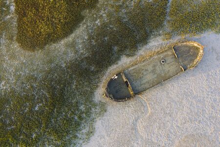 top view of a ship wrecked in a dry sea without water due to global warming, concept of drought and climate change emergencyの写真素材