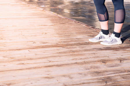 feet of an unrecognizable runner with running shoes on a wooden floor, concept of sport and healthy lifestyle, copy space for textの写真素材