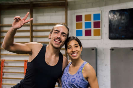 portrait of a happy sports couple at the gym, active and sporty lifestyle concept