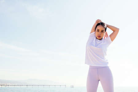 young asian sportswoman stretching arm outdoors, concept of sport and active lifestyle