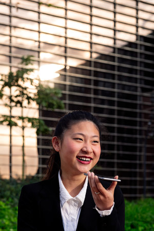 smiling business woman talking by phone outdoors