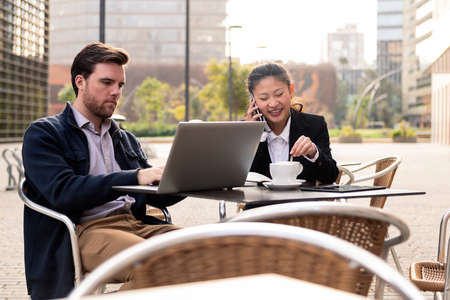 woman talking by phone over coffee with a partnerの写真素材