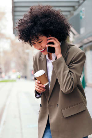 smiling young latin woman talking on the phone
