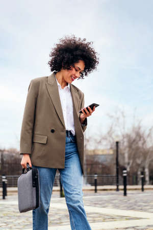 smiling young business woman walks using a phoneの写真素材