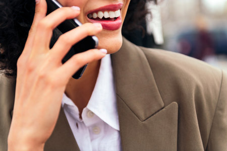 mouth of a smiling woman talking by mobile phoneの写真素材