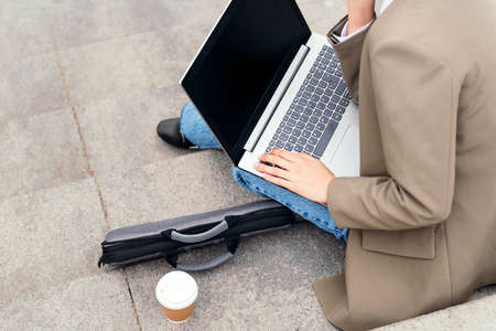 young woman working with laptop computer outdoorsの写真素材