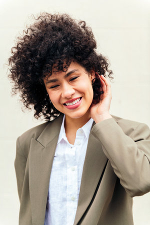 woman smiles happy touching her curly hairの写真素材