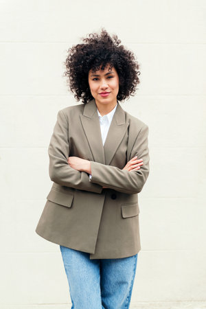 woman with arms crossed smiles looking at cameraの写真素材
