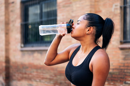 sportswoman drinking water during a workout