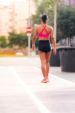 rear view of a sportswoman walking on the cityの写真素材