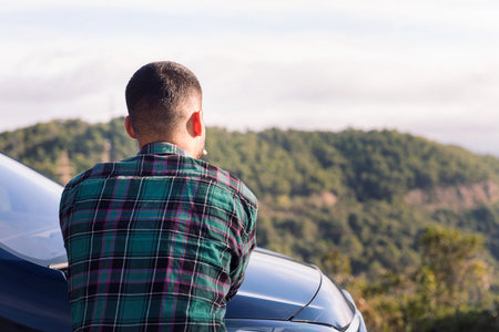 man leaning on his camper van observing natureの写真素材