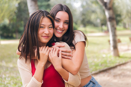 women looking at camera embracing and smilingの写真素材
