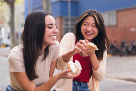 two friends laughing and having fun in a city parkの写真素材