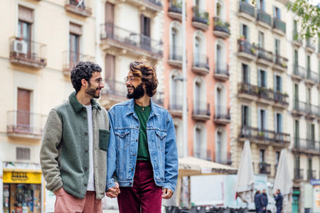 gay couple walking through the city holding handsの写真素材