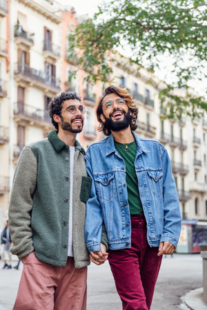 couple of gay men walking happy holding handsの写真素材