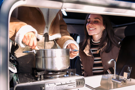 friends in a road trip cooking in camper vanの写真素材