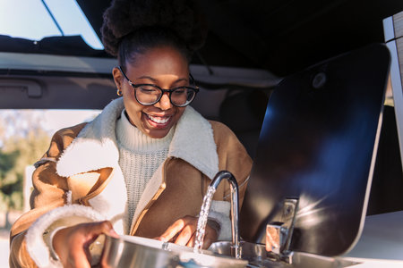 african woman cooking in a van during a journeyの写真素材