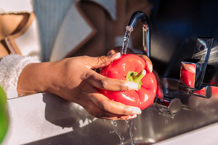 washing red pepper in the sink of a camper vanの写真素材