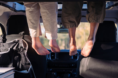 feet dangling off the elevated bed of a camper van