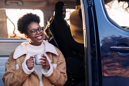woman laughing in a camper van with a cup of coffeeの写真素材