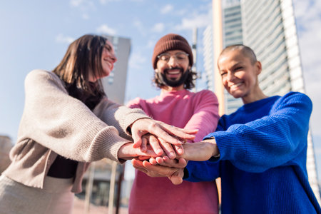 three smiling friends holding hands in friendship