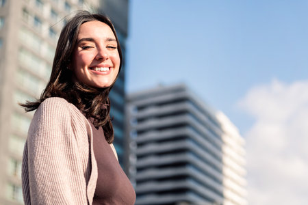 smiling young woman looking at camera on sunny dayの写真素材