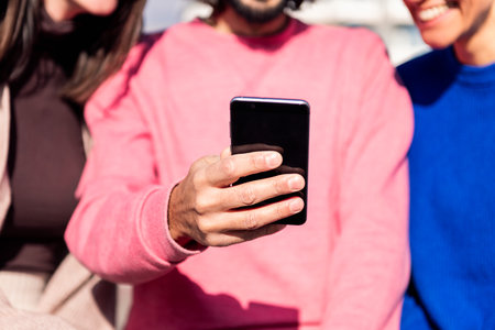 hand with mobile phone sharing with friendsの写真素材