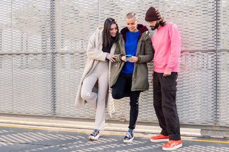 three happy young friends enjoying using phone