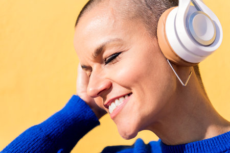 smiling woman listening to music on headphonesの写真素材