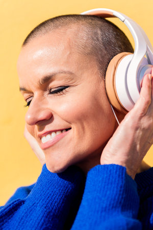 smiling woman listening to music on headphonesの写真素材