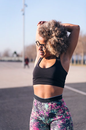 african fit woman stretching in an urban parkの写真素材