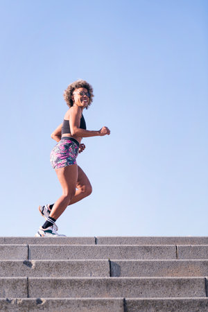 happy african american woman running outdoors