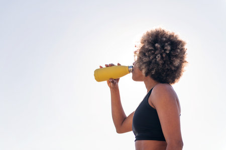 thirsty and tired runner drinking water outdoorsの写真素材