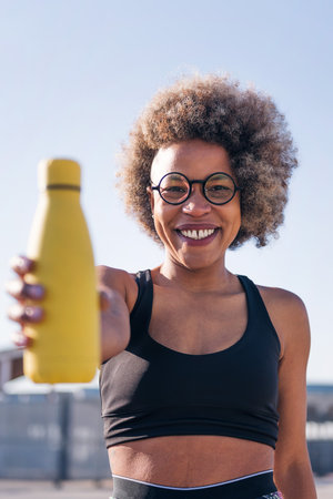 runner showing a water bottle while smilingの写真素材